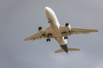 Flying airplane from below. Grey background.