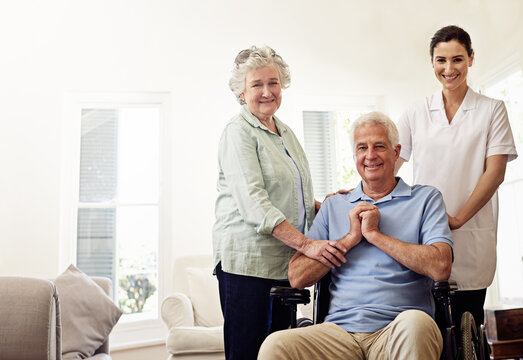 Portrait of old man in wheelchair, elderly couple with nurse and smile at nursing home for care and rehabilitation. Healthcare, disability and happy senior with caregiver and woman in living room.