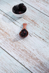 Ripe blackberries on a light wooden background.