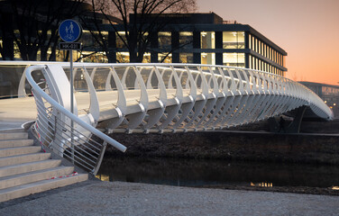 A new bridge in a modern style in Hradec Králové. An administrative building in the background.