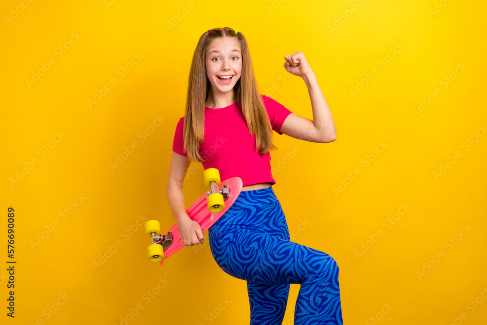 Canvas Prints photo of optimistic cute schoolgirl pink t-shirt showing v-sign hold skateboard clenching fist isola