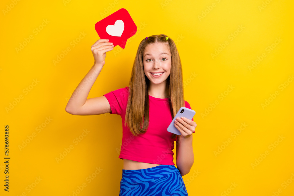 Poster Photo of funny teen lady wear vintage blue pants pink crop top use phone online instagram blog like notification isolated on yellow color background