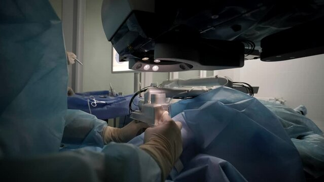 Laser vision correction. A patient and team of surgeons in the operating room during ophthalmic surgery