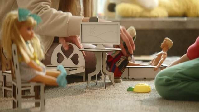 Close up of mother's hands playing with national culture doll and wooden toy furniture, games on the floor, nice artificial interior. Family playtime delight, exploring nationality. HQ 4k footage