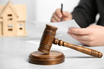 Construction and land law concepts. Man working at white table, focus on gavel