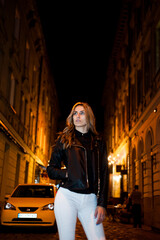Fototapeta premium Beautiful woman is walking in the night city.