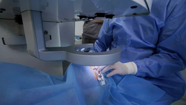Laser vision correction. A patient and team of surgeons in the operating room during ophthalmic surgery