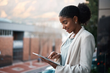 Go digital and get it done today. Shot of a young businesswoman using a digital tablet out on the...