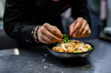 Chef cooking Caesar salad on restaurant kitchen