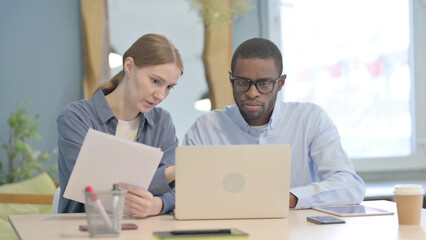 African Businessman and Businesswoman Doing Paperwork Together
