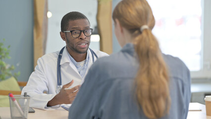 Obraz premium African Doctor Talking with Patient in Clinic