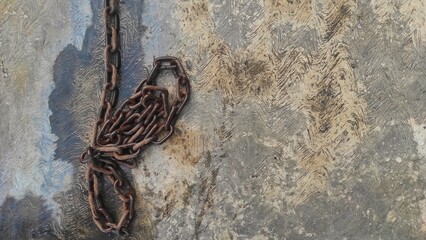 A rusty chain on the wet solid ground after rain