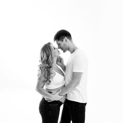 a couple waiting for a child in white T-shirts and jeans on a white background.