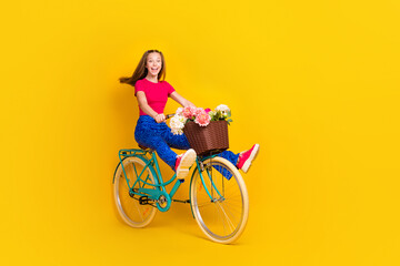 Photo of positive cute lady wear stylish clothes riding street enjoy summer trip moving empty space isolated on yellow color background