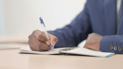 African Businessman Writing in Office, Close up
