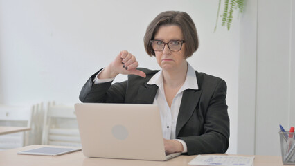 Thumbs Down by Old Businesswoman Working on Laptop