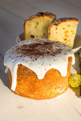 Easter cake on a white wooden background. Easter cake in a sunshine. Cake with chocolate. Slice of bread with butter.