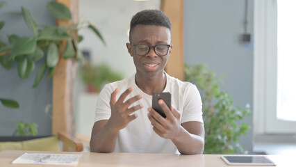 African Man Sad about Loss on Smartphone