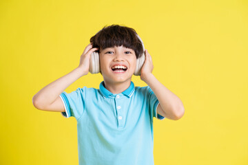 portrait of an asian boy posing on a yellow background © Q88