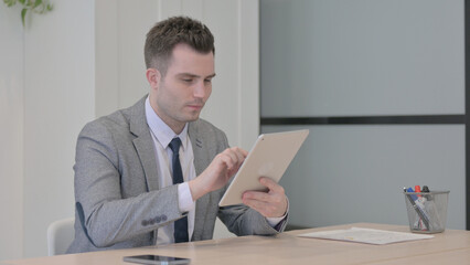 Young Businessman using Digital Tablet for Work