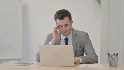 Young Businessman having Headache while Working on Laptop