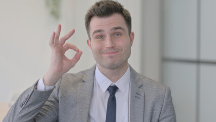 Portrait of Young Businessman showing Ok Sign