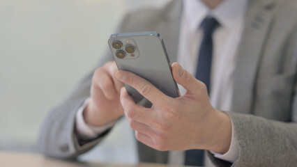 Close up of Young Businessman Browsing Internet on Smartphone