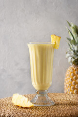 Asian traditional Pineapple lassi on gray background. Freshness cold beverage made of yogurt,...