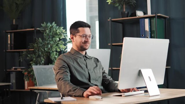 Handsome businessman employee in eyeglasses well job done, leaning back business man relax after hard working day finished project on computer stretching puts hands behind his head at workplace.