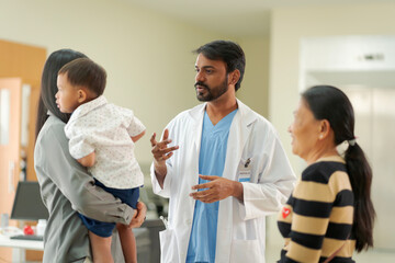 Fototapeta premium A kind doctor who treats pediatric patients. The child and his family brought him to see the doctor at the hospital because he was ill.