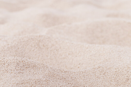 Fine Sand texture natural surface. Close up of sand on shore sea, white waves dunes, pink neutral color, minimal nature aesthetics wallpaper. Sandy beach for background, selective focus