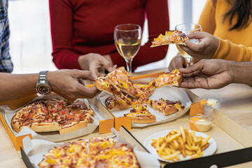 Group of employees eating Italian pizza Hand picked pizza in a lunch or dinner shop. Tasty seafood gravy sauce. Traditional Italian fast food on wooden table with drinking wine.