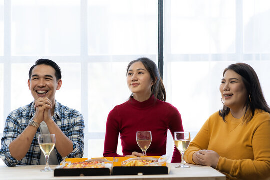 Group of employees eating Italian pizza Hand picked pizza in a lunch or dinner shop. Tasty seafood gravy sauce. Traditional Italian fast food on wooden table with drinking wine.