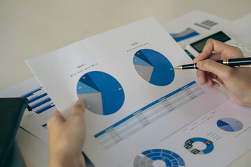 Asian ying businessman hand holding pen pointing at document. Financial graph. Plan. Marketing...
