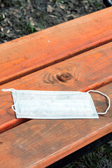 Protective medical mask forgotten on park bench