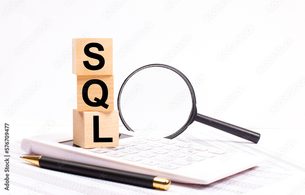 Poster on a white calculator, next to a magnifying glass and a black pen, wooden cubes marked sql structure