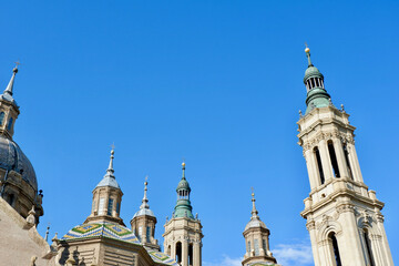 Fototapeta na wymiar Gothic tops of the catholic church of El Pilar against a clear blue sky in Zaragoza, Community of Aragon, Spain