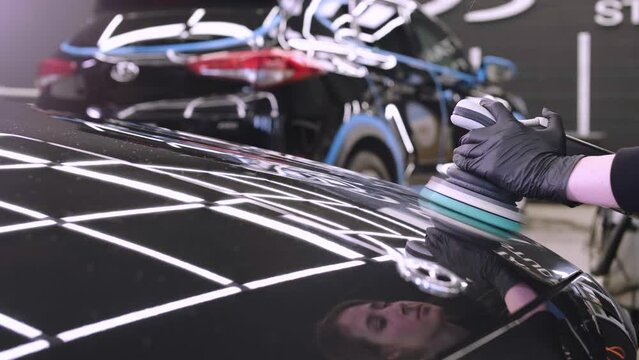 Professional car detailing using machinery and polishers for paint restoration.