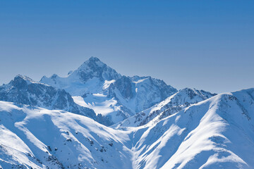 Fototapeta na wymiar View of Nursultan Peak from a forest pass in winter near Almaty