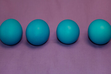 Blue Easter eggs on a purple tablecloth. Religion, easter concept.