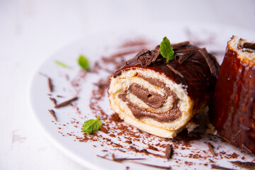 Rolled chocolate cake decorated as a Christmas log with chocolate.