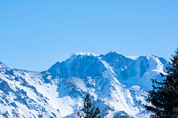 Fototapeta na wymiar Panorama of Talgar Peak near Almaty. View of Talgar Peak from the forest pass in winter.