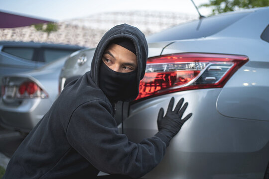 robber in black mask with car. robbery and crime concept. car theft concept.