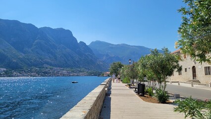 view of the sea and the walking street with mountains in the background in Kotor Bay, Montenegro