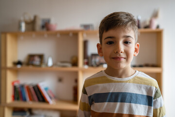 Fototapeta premium portrait of one caucasian boy preschooler child at home waist up serious