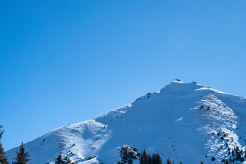 View of Bukreev Peak from a forest pass in winter near Almaty
