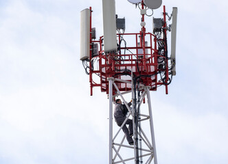 The fitter climbs to the top of the telecommunications tower with equipment, working at height....