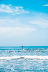 The man is surfing. A novice surfer on the waves in the ocean off the coast of Asia on the island of Bali in Indonesia.