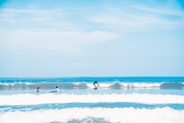 The man is surfing. A novice surfer on the waves in the ocean off the coast of Asia on the island of Bali in Indonesia.