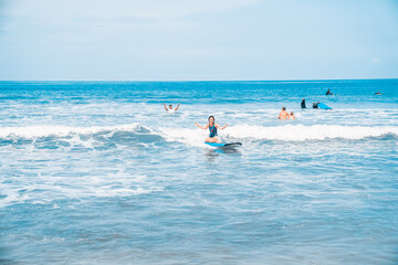 The man is surfing. A surfer on the waves in the ocean off the coast of Asia on the island of Bali in Indonesia. Sports and extreme. Beauty and health. Fashion and beach style.